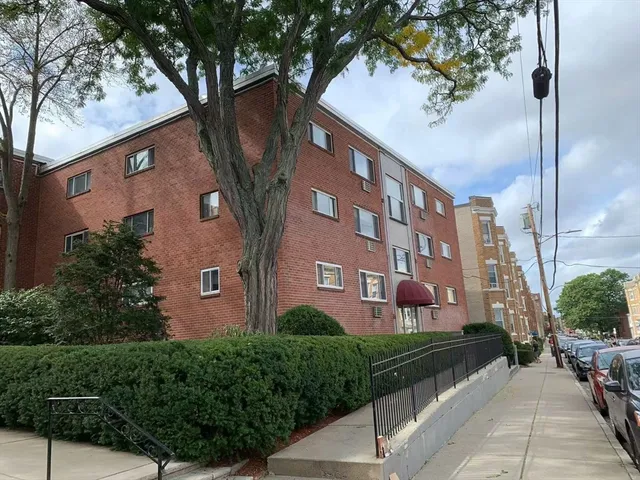 a front view of a building with a garden