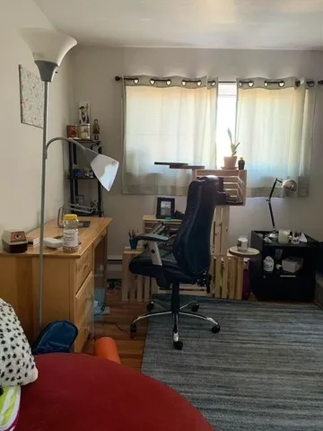 a view of a workspace with furniture and a window