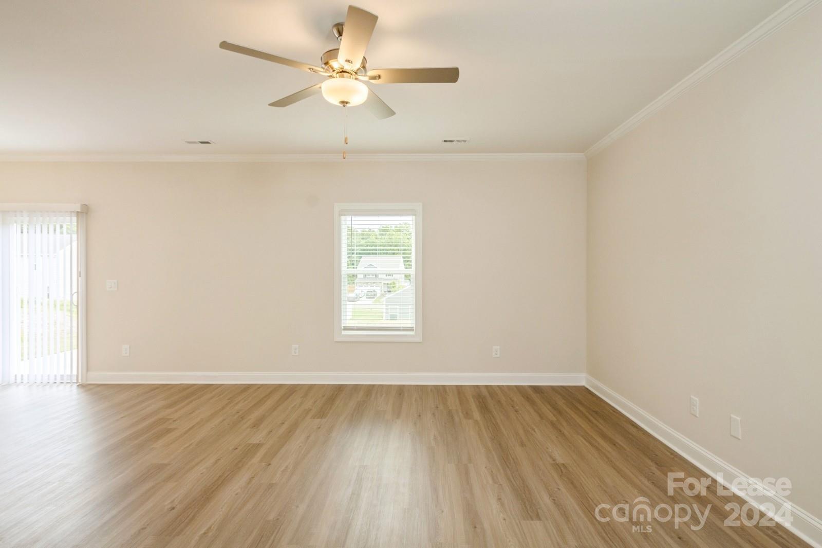 131 Brixham Loop Troutman, NC 28166 - Photo 4 of 26 an empty room with wooden floor and windows