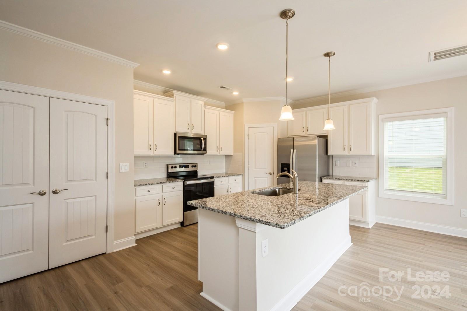 131 Brixham Loop Troutman, NC 28166 - Photo 6 of 26 a kitchen with kitchen island granite countertop a sink center island stainless steel appliances and cabinets
