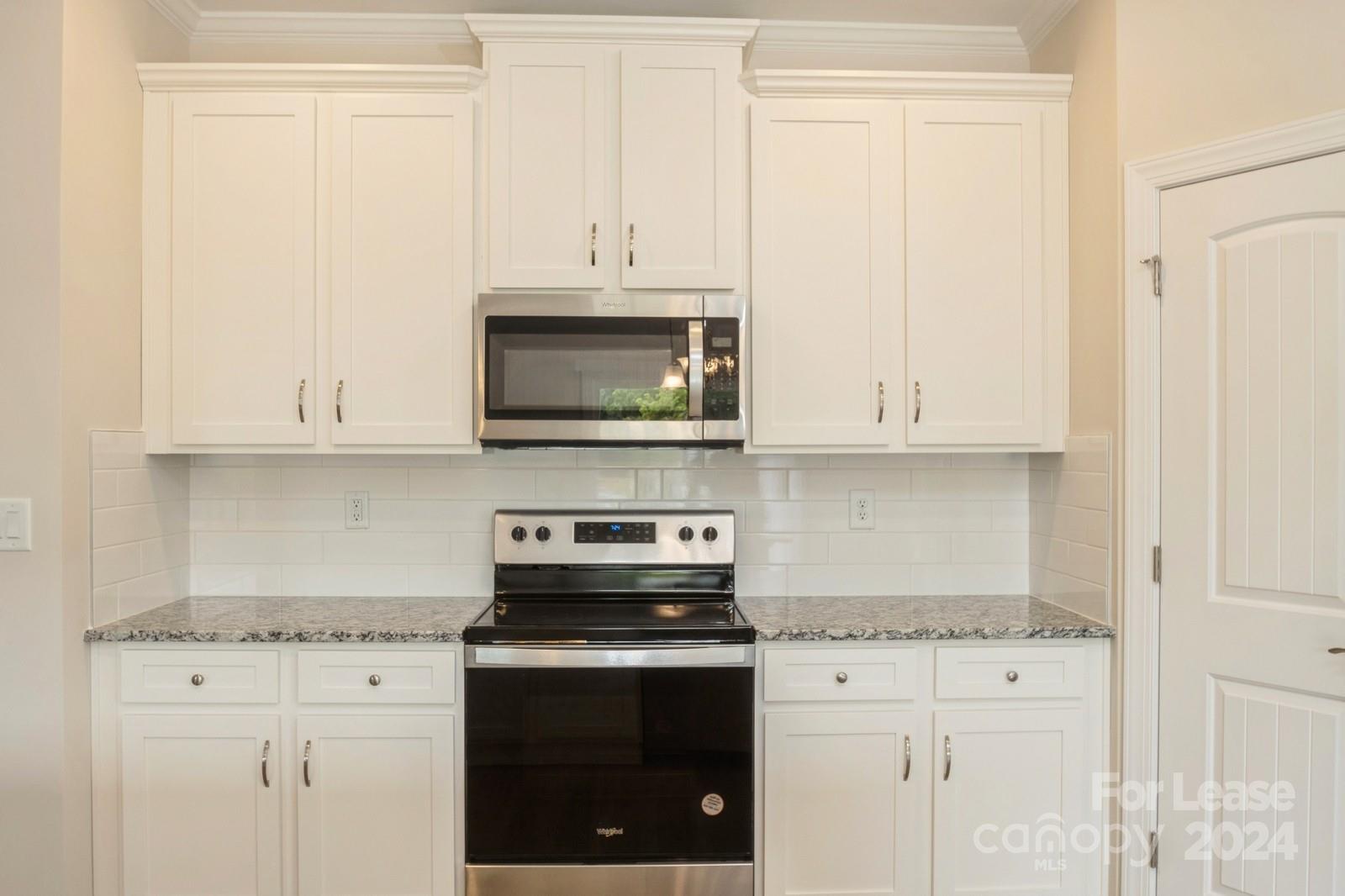 131 Brixham Loop Troutman, NC 28166 - Photo 8 of 26 a kitchen with stainless steel appliances granite countertop white cabinets a sink and dishwasher