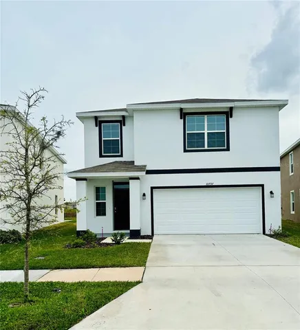 a front view of a house with a yard and garage