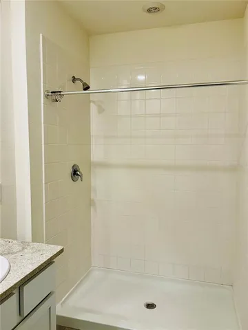 a bathroom with a granite countertop sink toilet and shower