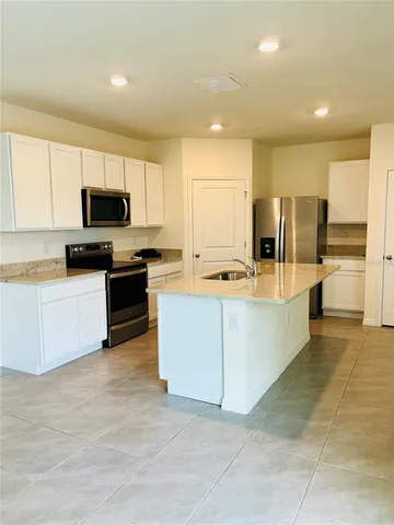 a kitchen with kitchen island granite countertop a stove top oven and cabinets