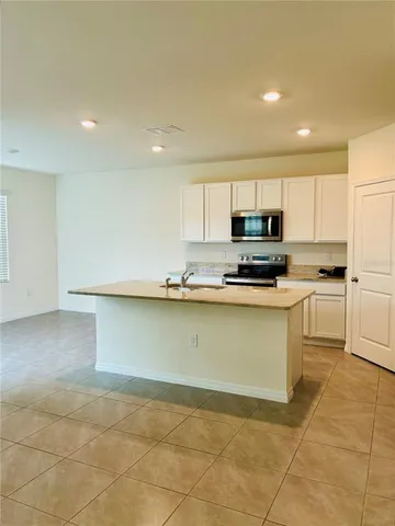 a kitchen with granite countertop a sink a stove top oven and cabinets