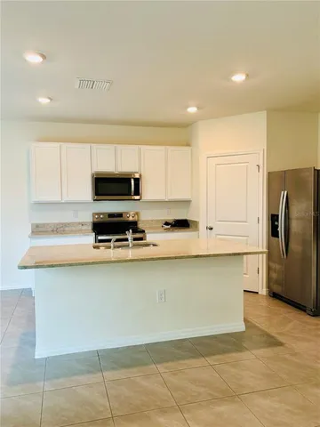 a kitchen with stainless steel appliances granite countertop a refrigerator and a stove top oven