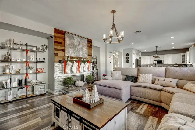 a living room with furniture kitchen view and a chandelier