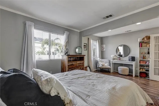 a bedroom with a bed and dresser with mirror