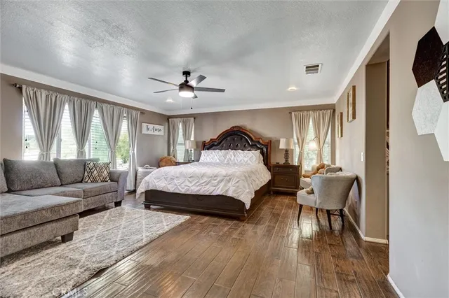 a spacious bedroom with a bed a couch and a large window