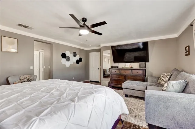 a bedroom with a bed a flat screen tv and a couch