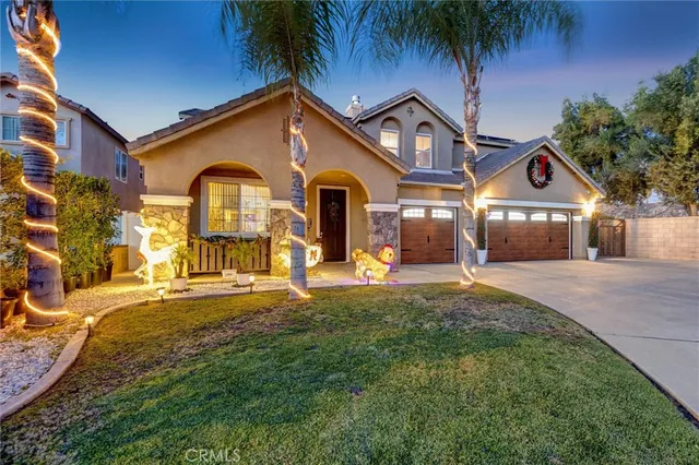 a front view of a house with a yard and potted plants