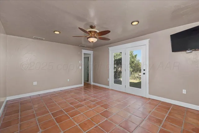 wooden floor in an empty room with a chandelier fan