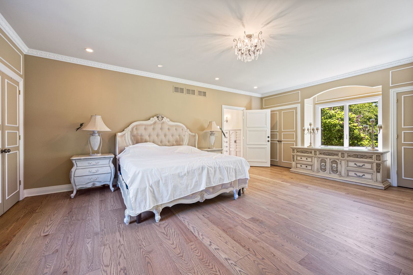 541 Merri Oaks Road Barrington Hills, IL 60010 - Photo 28 of 60 a spacious bedroom with a bed a chandelier and a window