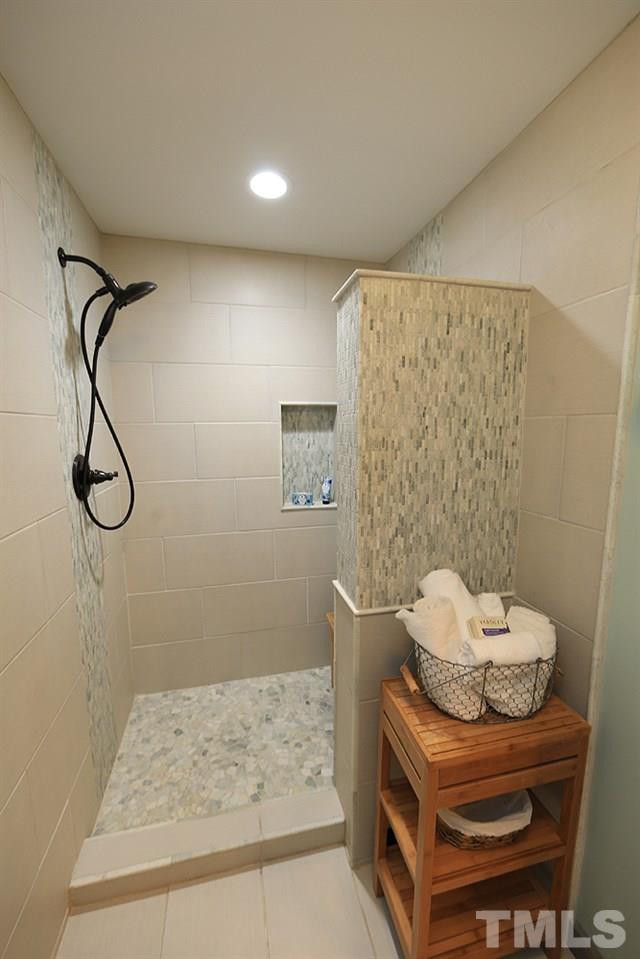 6579 New Market Way, Unit 6579 Raleigh, NC 27615 - Photo 11 of 22 a bathroom with a granite countertop sink a toilet and a shower
