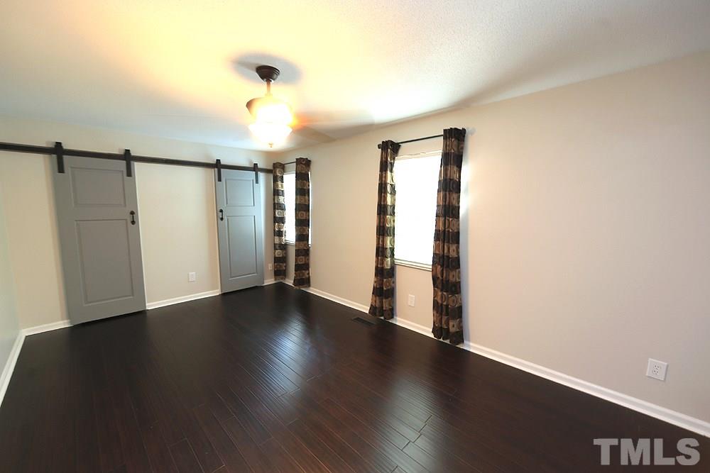 6579 New Market Way, Unit 6579 Raleigh, NC 27615 - Photo 13 of 22 a view of an empty room with wooden floor and a window
