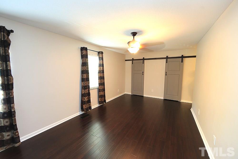 6579 New Market Way, Unit 6579 Raleigh, NC 27615 - Photo 14 of 22 an empty room with wooden floor and white walls