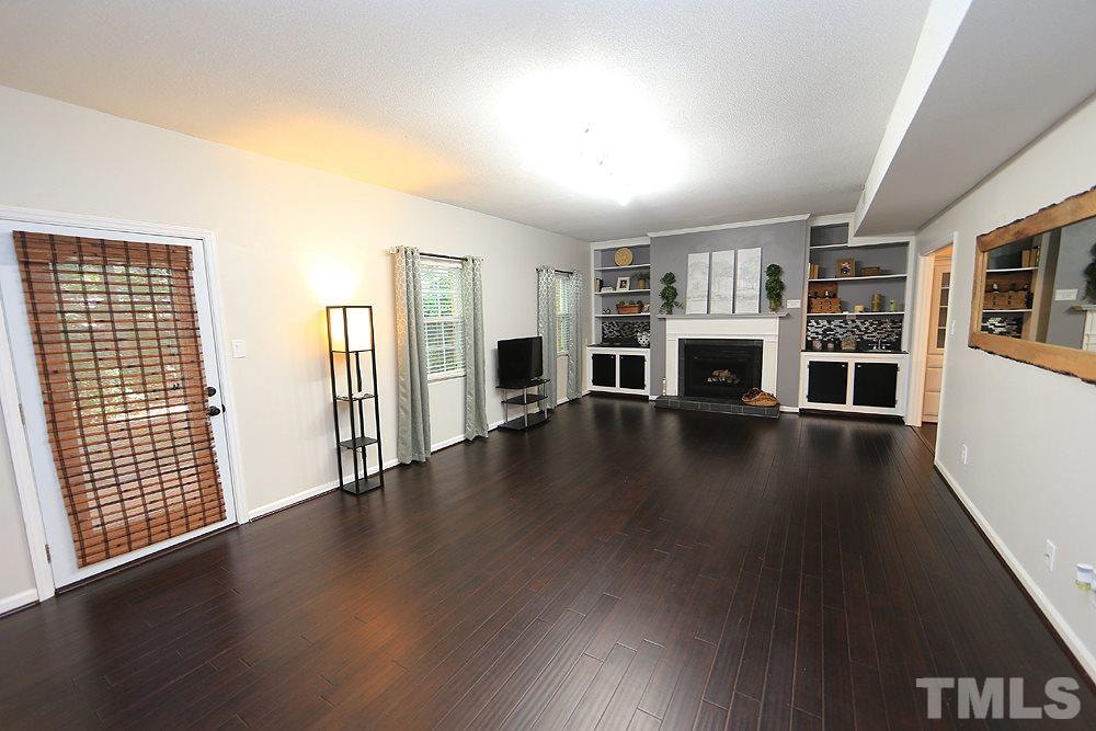 6579 New Market Way, Unit 6579 Raleigh, NC 27615 - Photo 5 of 22 wooden floor in an empty room with a fireplace and wooden floor