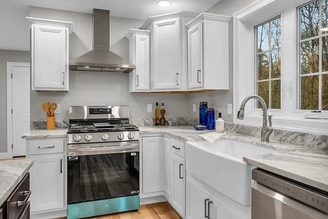 a kitchen with stainless steel appliances granite countertop a sink stove and cabinets