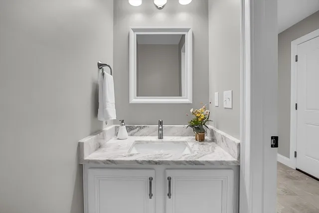 a bathroom with a granite countertop sink and a mirror