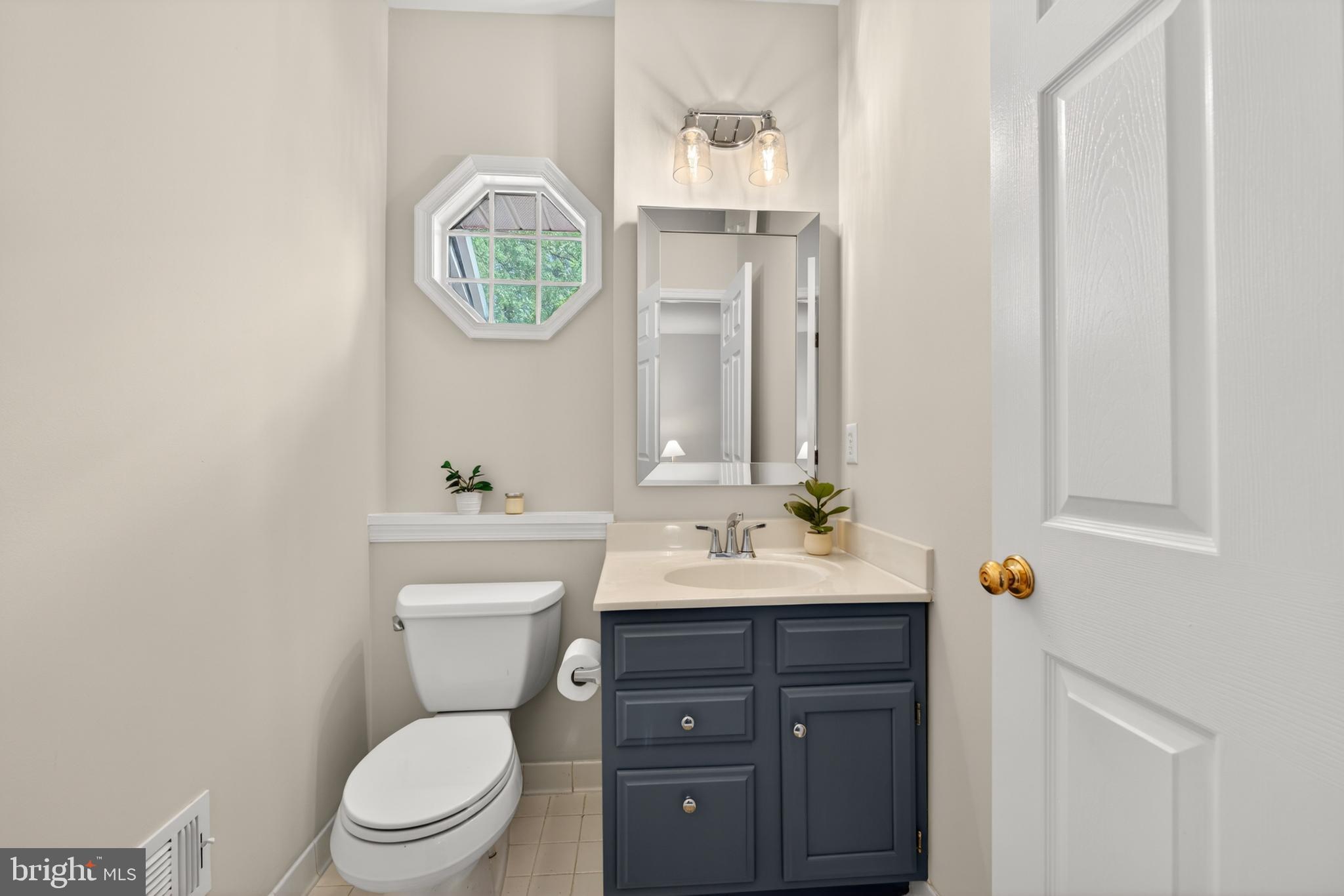 1409 Park Garden Lane Reston, VA 20194 - Photo 5 of 41 a bathroom with a toilet a sink and a mirror
