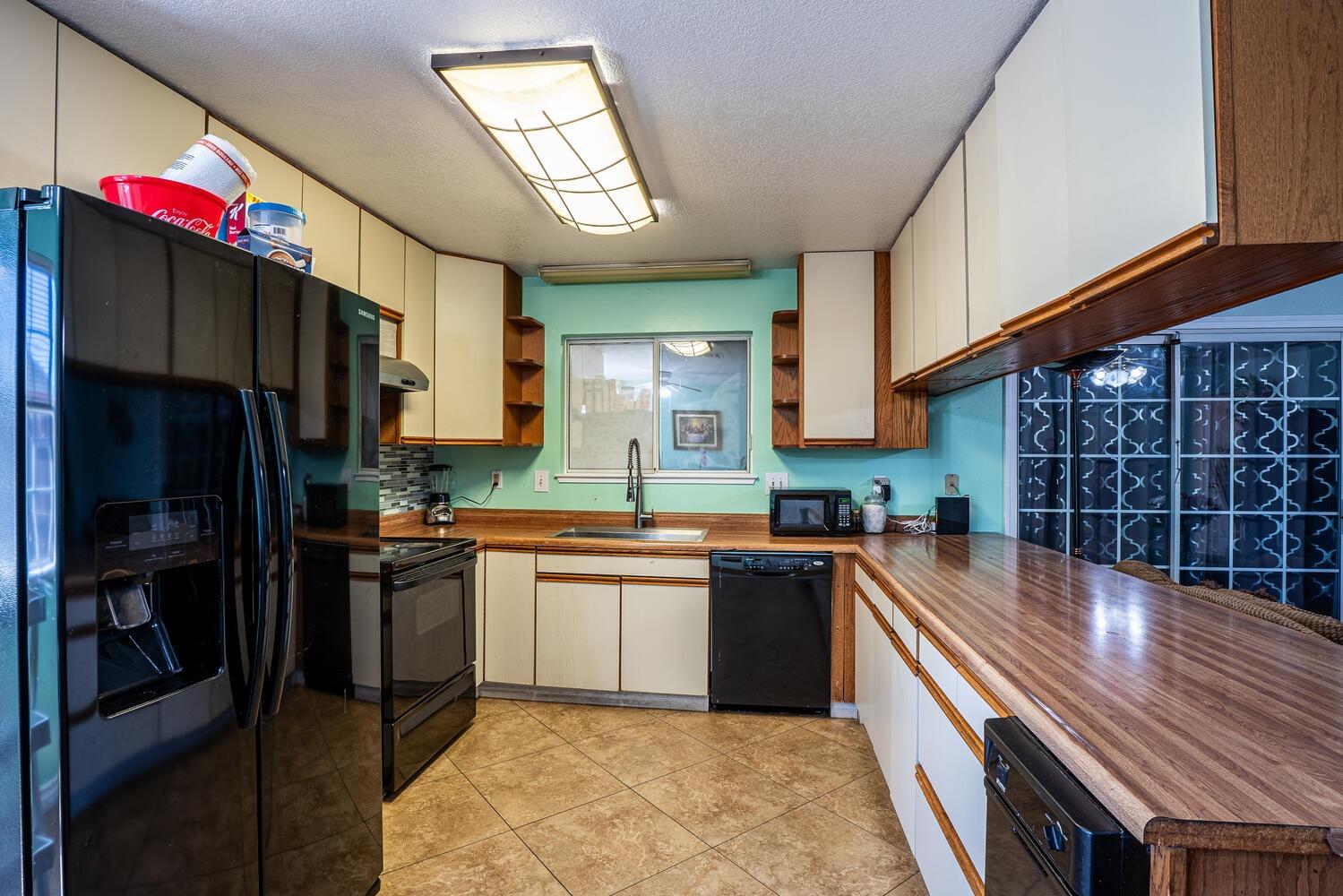 802 West Center Street Manteca, CA 95337 - Photo 12 of 29 a kitchen with stainless steel appliances granite countertop a refrigerator a sink dishwasher a stove a dining table and chairs with wooden floor