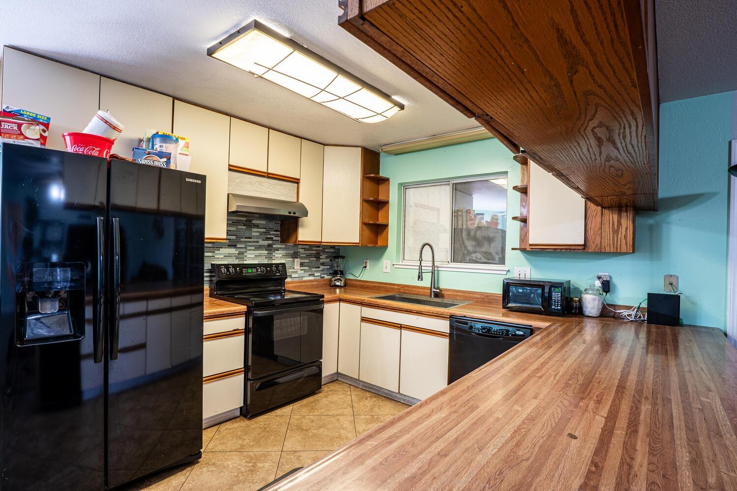 802 West Center Street Manteca, CA 95337 - Photo 15 of 29 a kitchen with stainless steel appliances granite countertop a refrigerator a sink dishwasher a stove and white cabinets with wooden floor