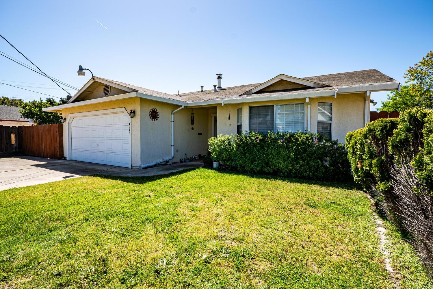 802 West Center Street Manteca, CA 95337 - Photo 2 of 29 a front view of a house with a yard and garage