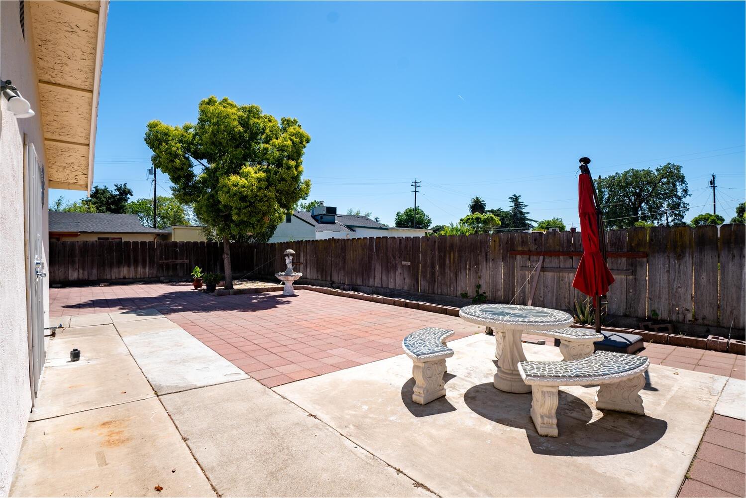 802 West Center Street Manteca, CA 95337 - Photo 26 of 29 a view of a backyard with table and chairs potted plants with wooden fence