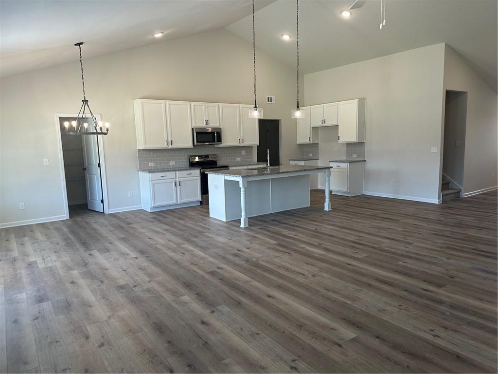 315 Rodeo Drive Auburn, GA 30011 - Photo 4 of 33 a kitchen with stainless steel appliances kitchen island granite countertop a refrigerator a oven and a wooden floors