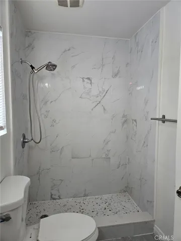 a bathroom with a toilet and a shower