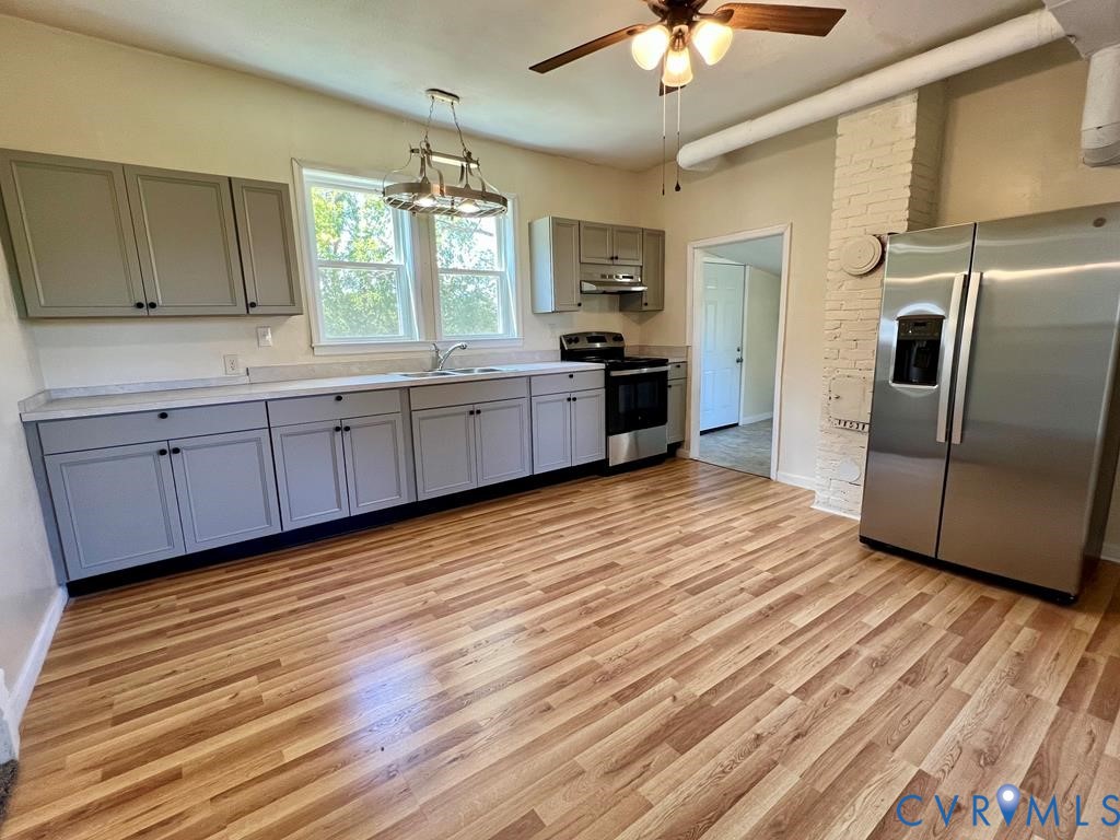 40 Coan Wharf Road Heathsville, VA 22473 - Photo 9 of 28 a kitchen with stainless steel appliances kitchen island granite countertop a refrigerator a sink dishwasher a stove with wooden cabinets and floor