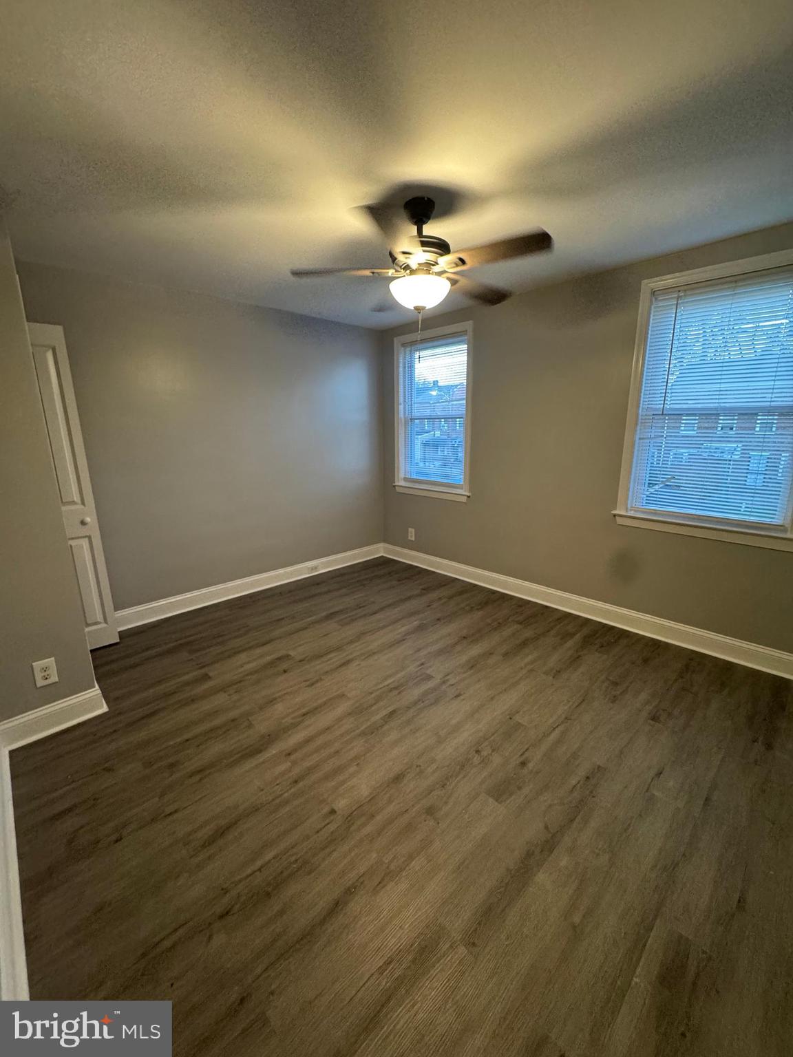 2858 Bookert Drive Baltimore, MD 21225 - Photo 3 of 4 an empty room with wooden floor chandelier fan and windows