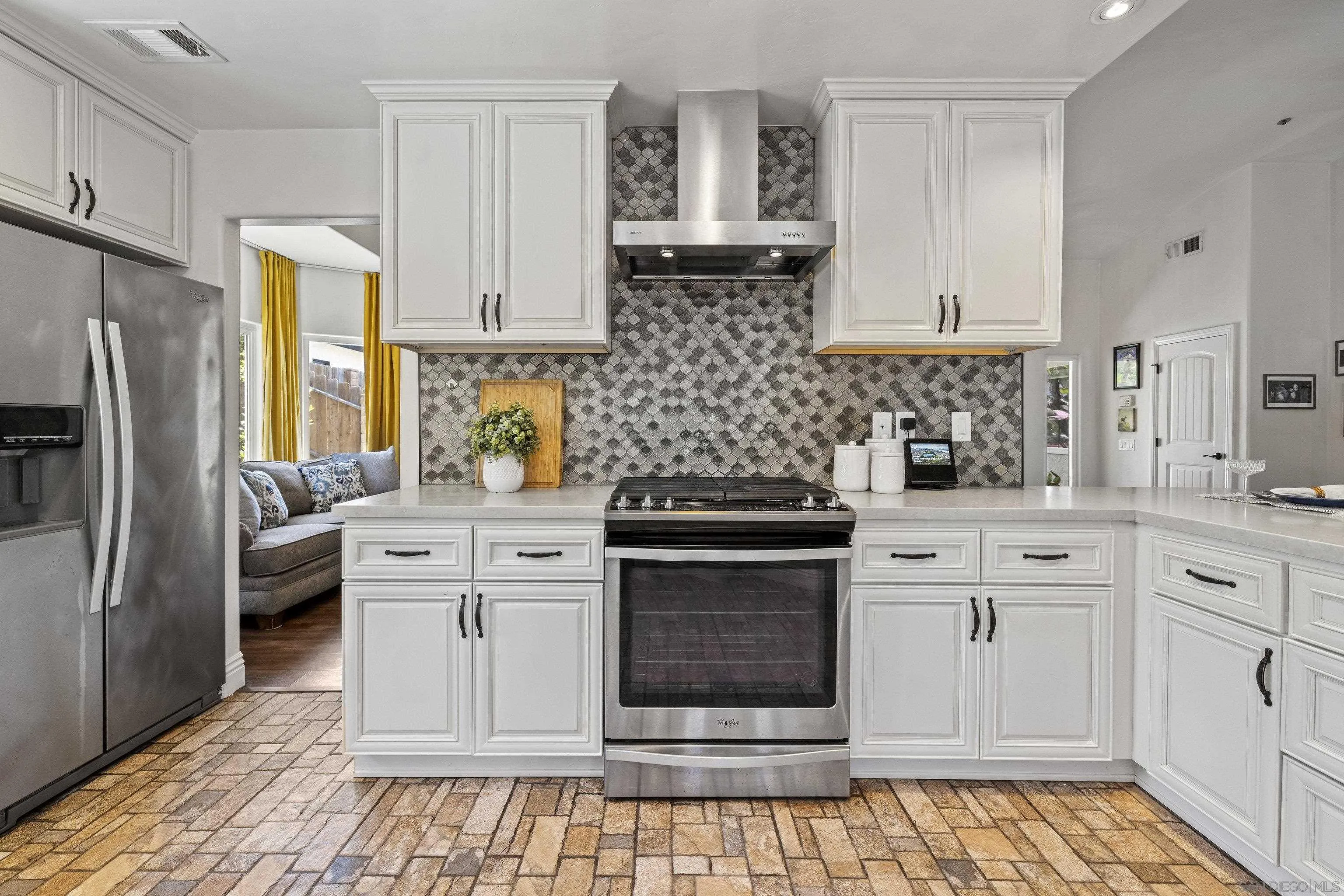 3127 Rio Way Spring Valley, CA 91977 - Photo 19 of 45 a kitchen with stainless steel appliances white cabinets and a stove a refrigerator with wooden floor
