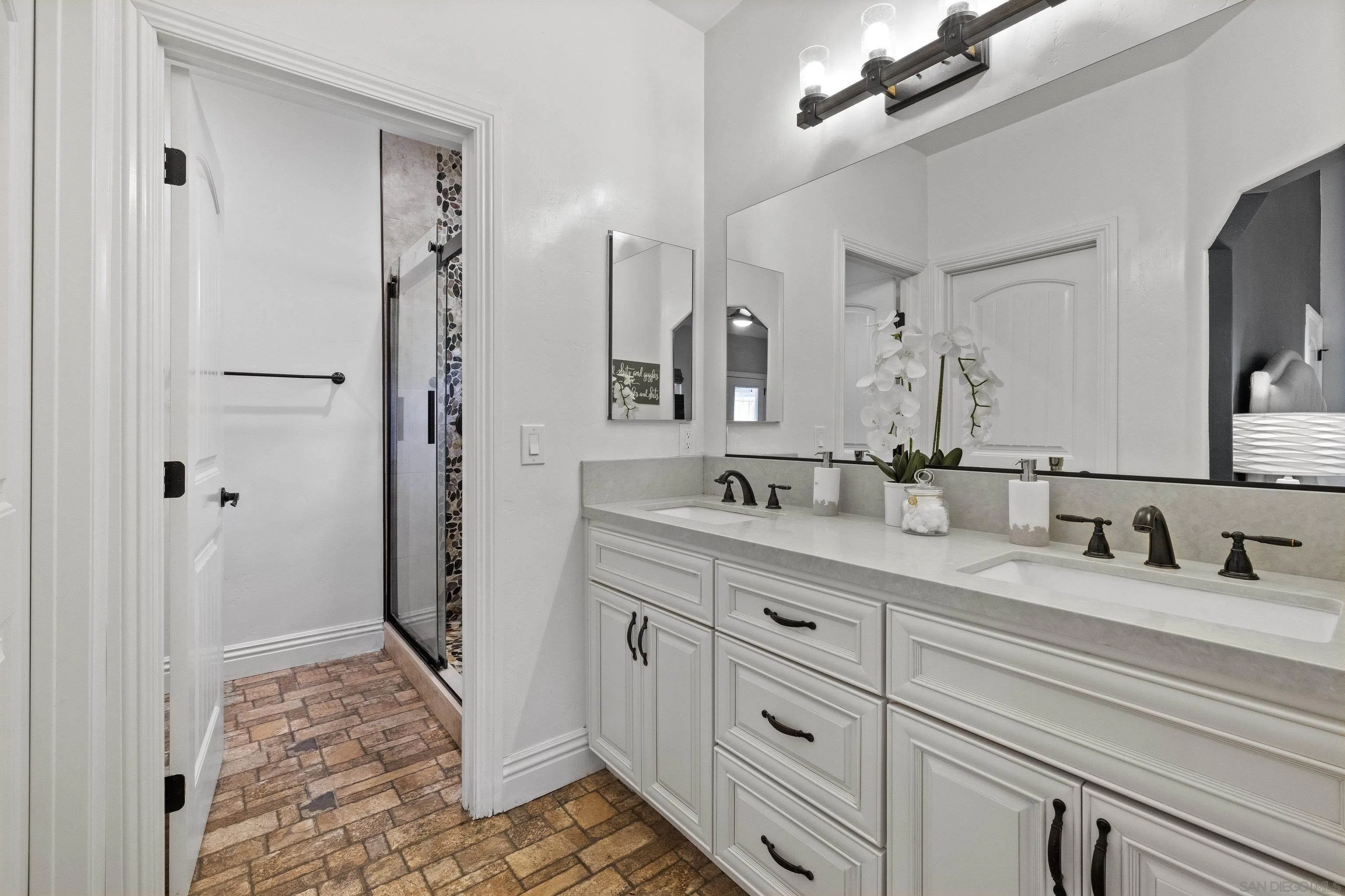3127 Rio Way Spring Valley, CA 91977 - Photo 25 of 45 a bathroom with double sink and a mirror