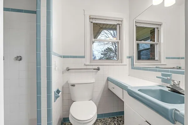 a bathroom with a sink toilet and window