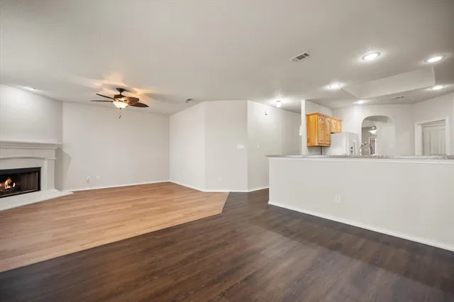 a kitchen with stainless steel appliances granite countertop a refrigerator a stove top oven a sink and dishwasher with wooden floor