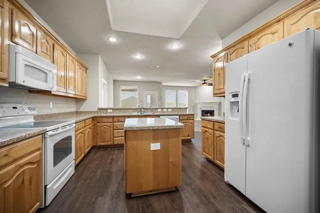 a large kitchen with stainless steel appliances granite countertop a stove a sink and a microwave