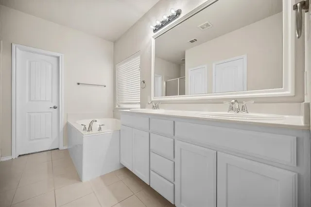 a bathroom with a tub a sink and a window