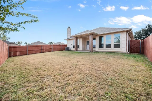 a front view of house with yard and trees in the background