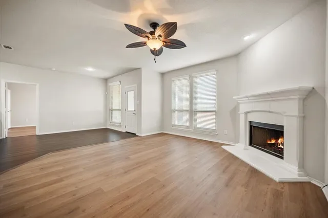a view of empty room with wooden floor and fireplace