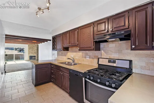 a kitchen with stainless steel appliances granite countertop a sink stove and cabinets