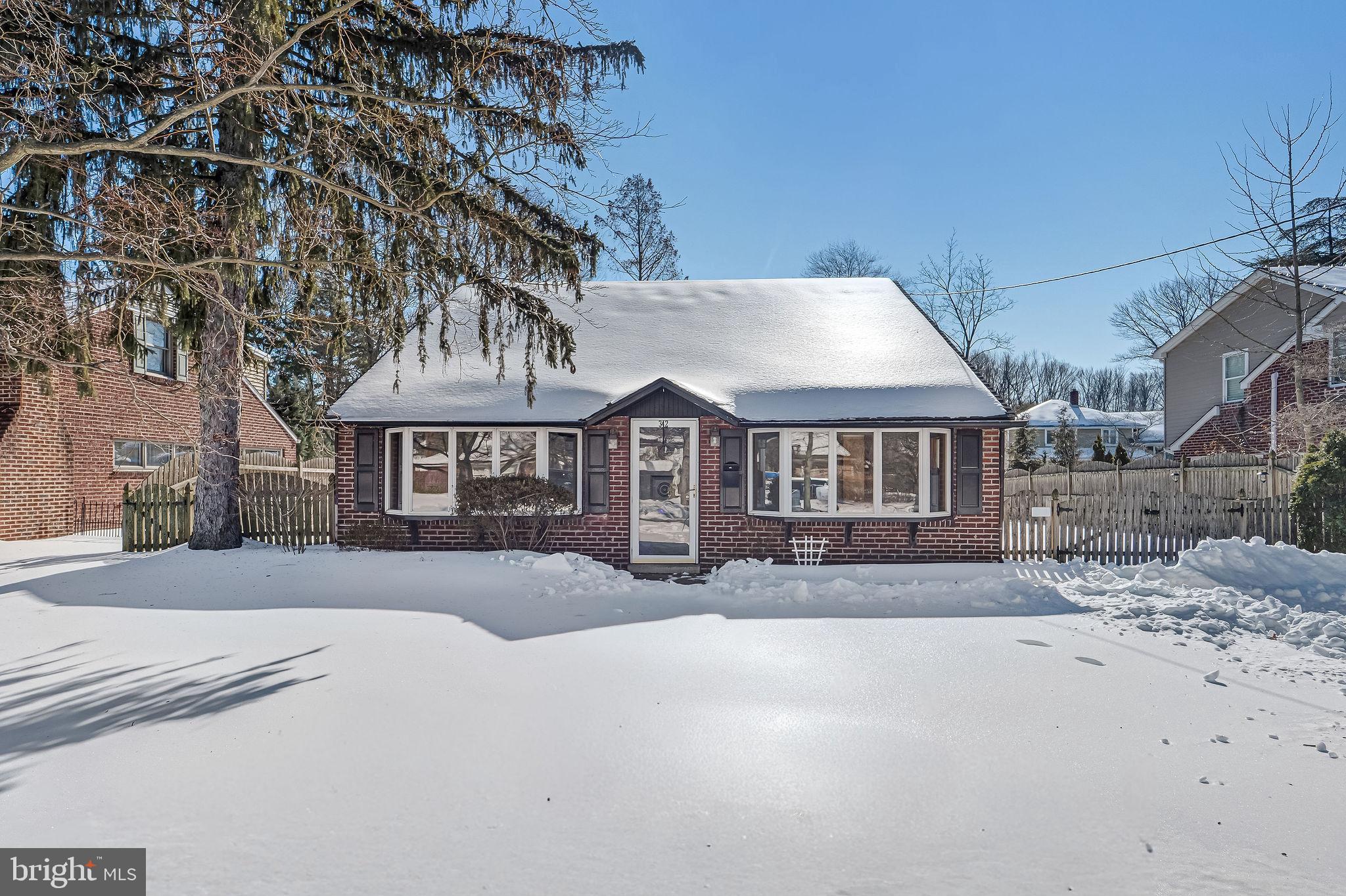 Charming brick home blanketed in snow.