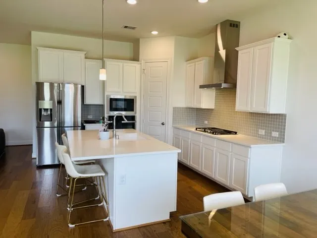 a kitchen with stainless steel appliances granite countertop a sink refrigerator and cabinets