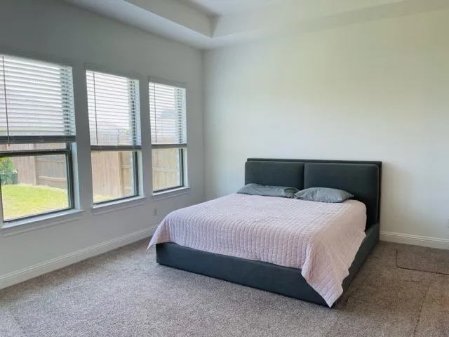 a bedroom with a bed and next to a window