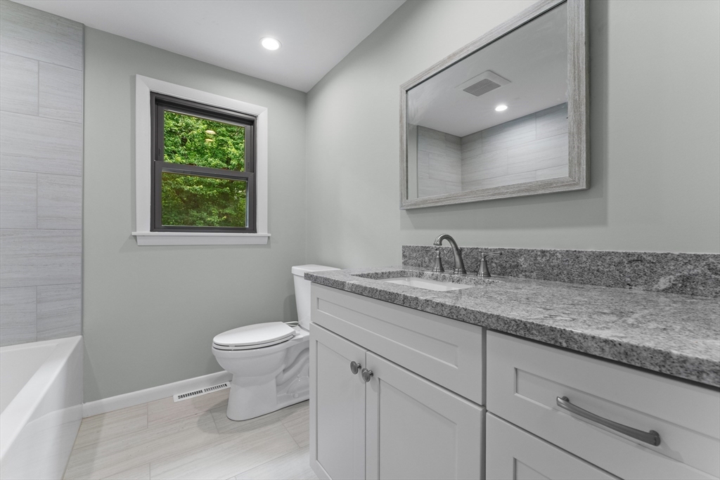 50 Farm Street Bellingham, MA 02019 - Photo 11 of 16 a bathroom with a granite countertop toilet sink and mirror