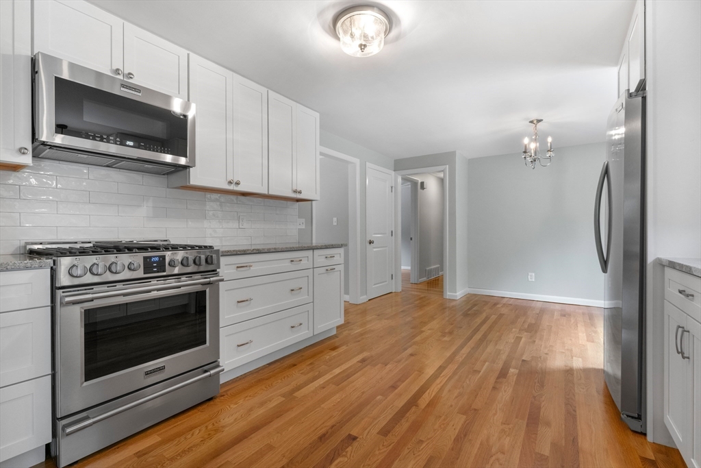 50 Farm Street Bellingham, MA 02019 - Photo 3 of 16 a kitchen with granite countertop a stove a microwave and refrigerator