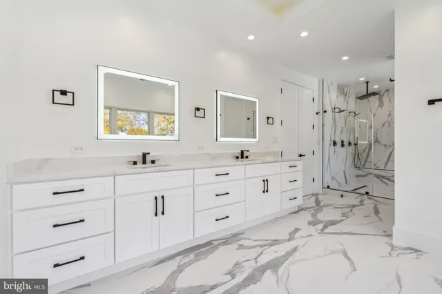 a bathroom with a toilet sink vanity and shower