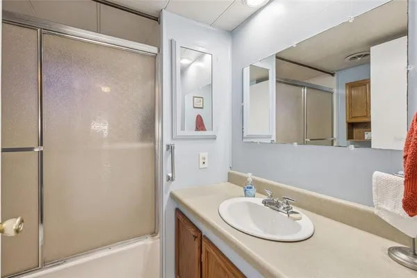 a bathroom with a sink vanity tub and a mirror