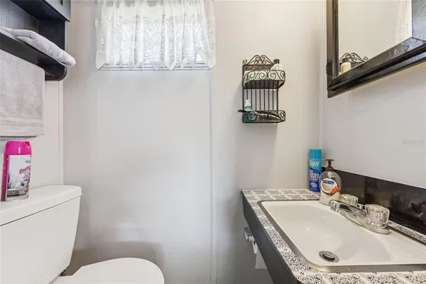 a bathroom with a sink vanity mirror and toilet