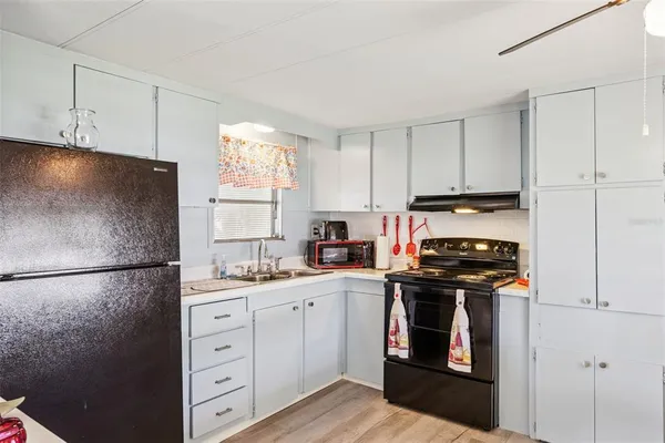 a kitchen with a sink stove and refrigerator